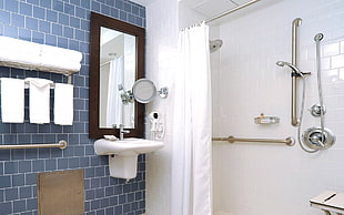 white ceramic sink near stainless steel showerhead